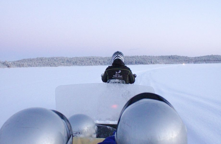 Snowmobile sleigh pulled on top of arctic lake in Inari Lapland Finland. Photo by Miika Leivo.