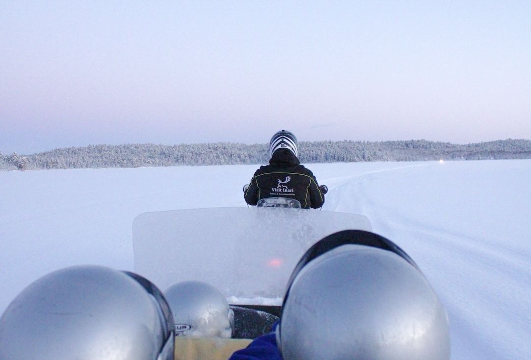 Snowmobile sleigh pulled on top of arctic lake in Inari Lapland Finland. Photo by Miika Leivo. 