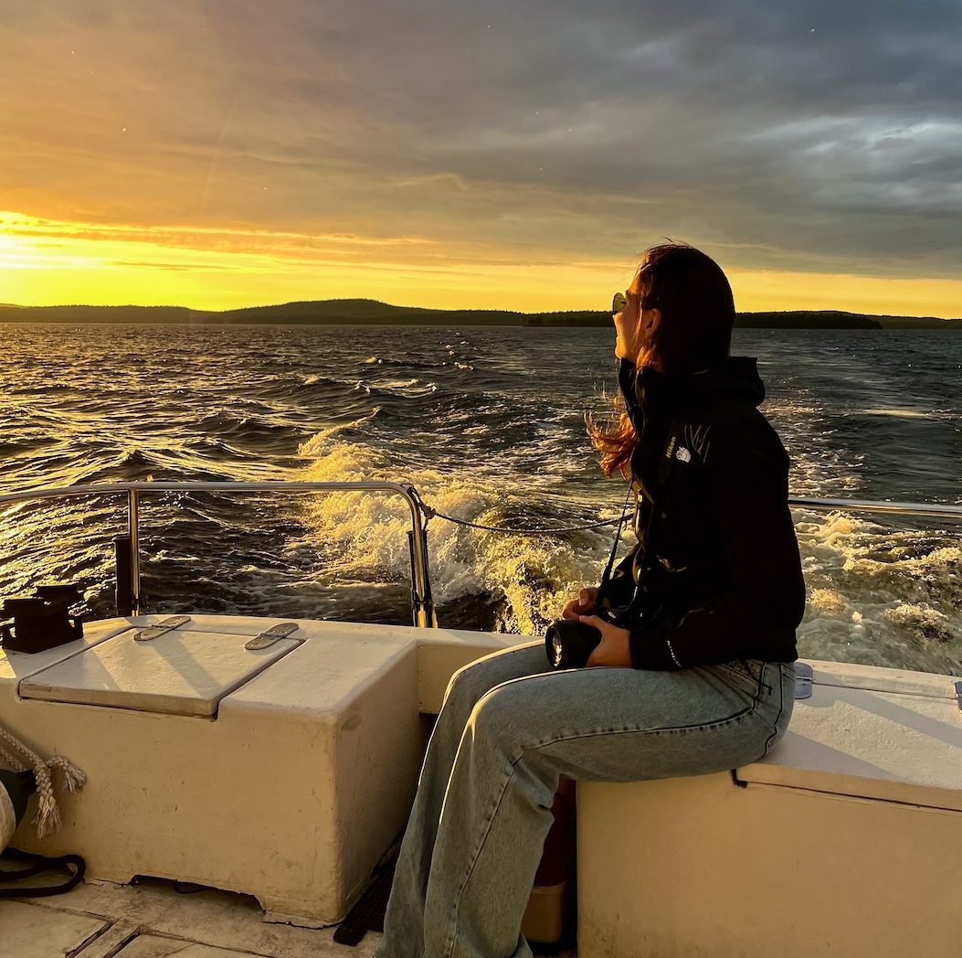 Midnight sun cruise. A person sitting on a boat enjoying the views over Lake Inari, Lapland Finland during the midnight summer in July. 