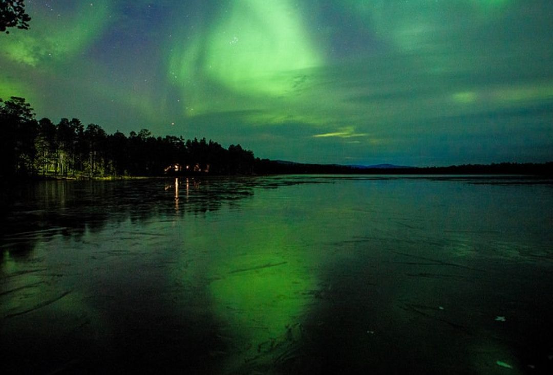 View to the lake under northern lights.