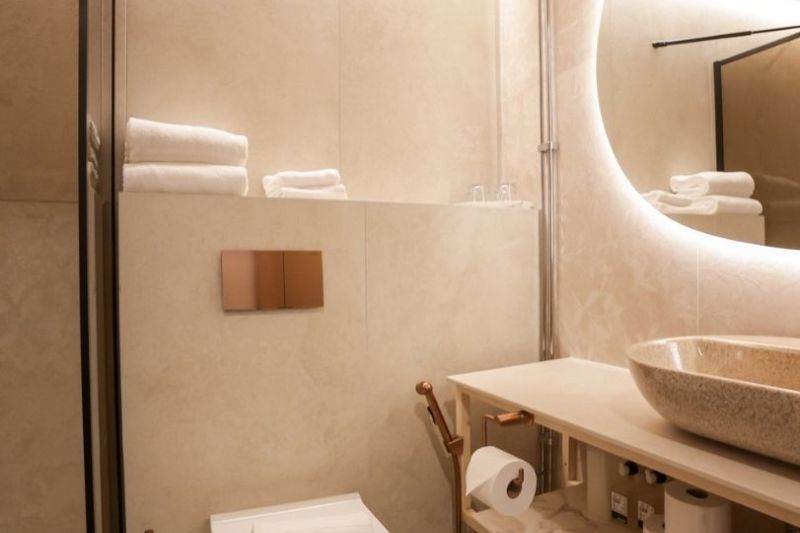 Modern bathroom with sink, toilet, and glass shower enclosure.