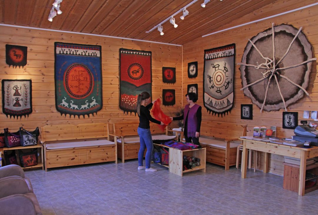 Handcraft exhibition in a room. Colorful art rugs hanging on walls.
