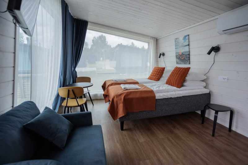 Interior view of studio cabin bedroom with two single beds and floor-to-ceiling window