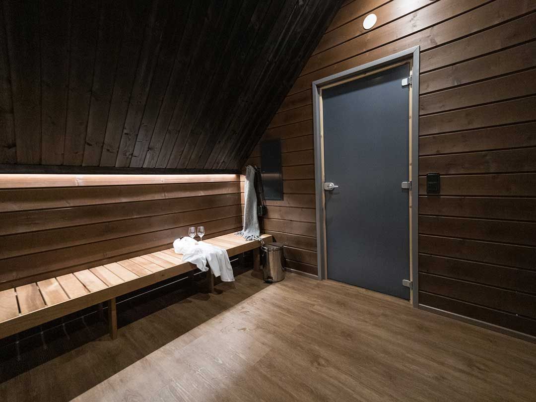 Saunan pukuhuone puisilla penkeillä ja pyyhe aseteltuna penkille.