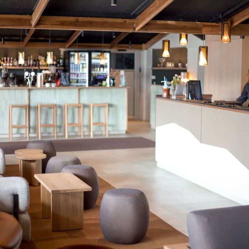 Hotel Inari reception with multiple seatings and a bar.