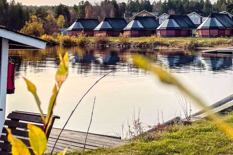Vastarannalta katsottuna useita Lomakylä Inarin mökkejä ihan rannan läheisyydessä.