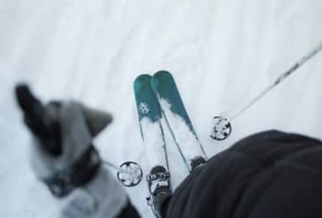 Sliding snowshoes and poles on snow in skiers feet.