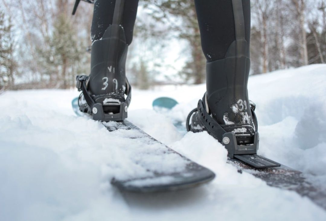 Skiier foot in sliding snowshoes in thick snow.
