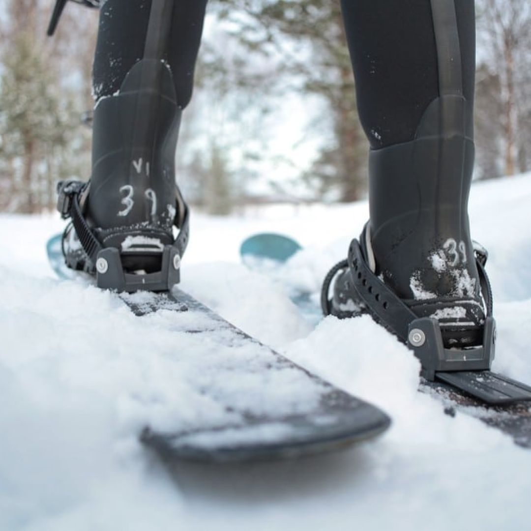 Skiier foot in sliding snowshoes in thick snow.