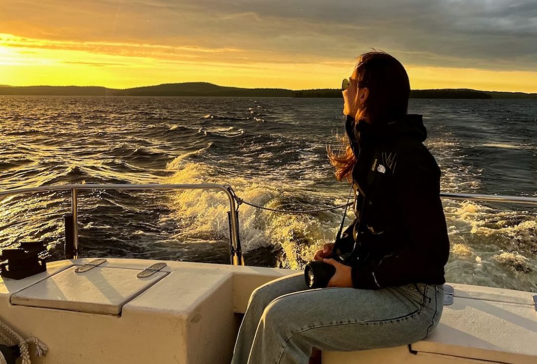 Midnight sun cruise. A person sitting on a boat enjoying the views over Lake Inari, Lapland Finland during the midnight summer in July. Photo by thenewjourney.nl
